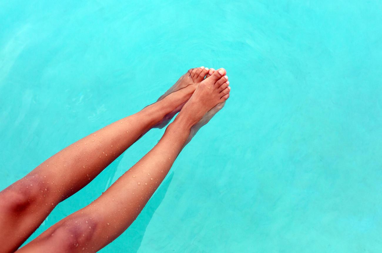 Tanned legs against aqua waters