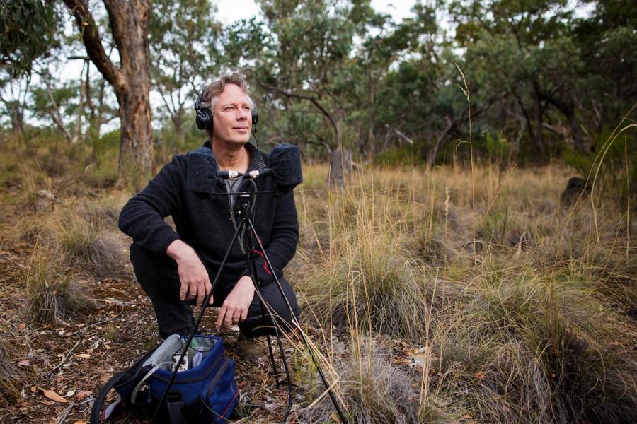 Andrew Skeoch sitting in nature with recording equipment